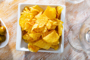 Popular beer snack in bars and cafes is potato chips and pickled olives. Snack is served with light alcoholic beverages.
