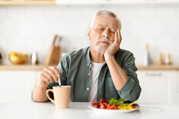 Fatigue Concept. Tired Senior Man Napping In Kitchen During Breakfast At Home
