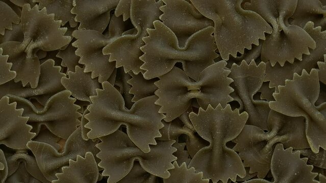 Italian green farfalle pasta background. Table spin.