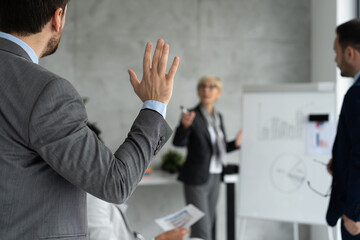 A man raises his hand at a business meeting