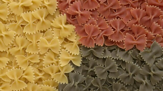 Italian tricolore farfalle pasta background with separated colours.  Table spin. 