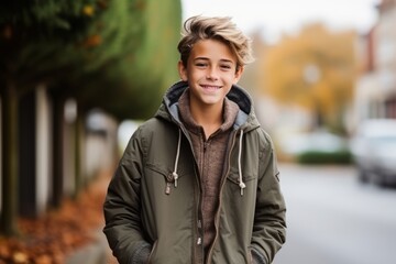 Portrait of a cute young boy in the autumnal street.