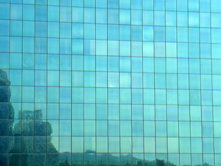 Building glass, glass building on cloudy blue sky background, blue sky reflected in windows of modern office building.   