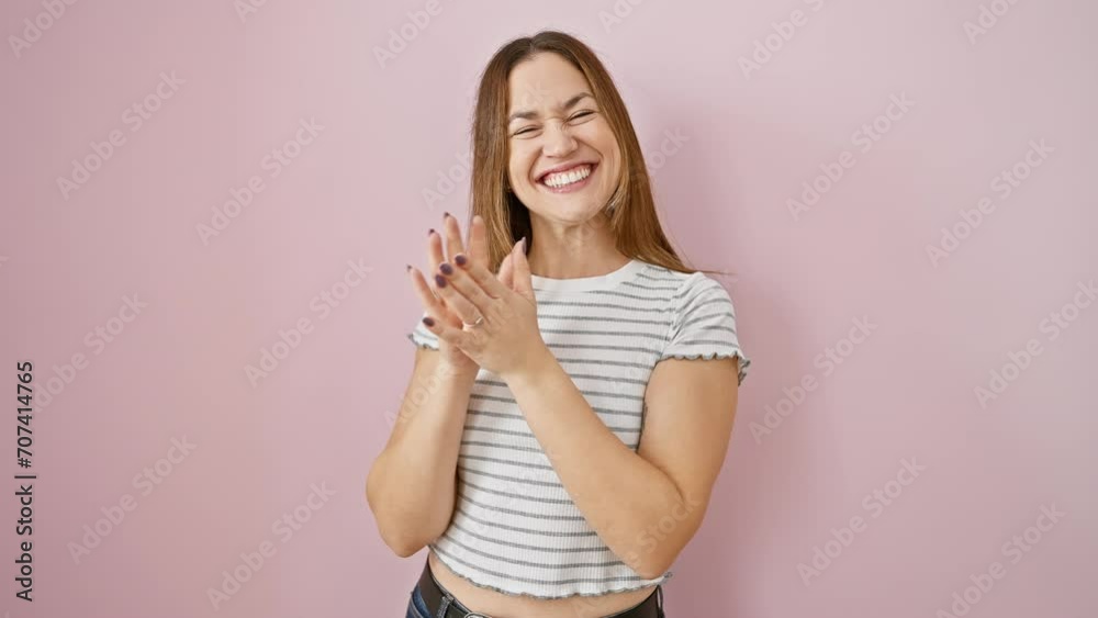 Canvas Prints Exuberant young woman with sparkling blue eyes and a big, victorious smile, joyfully cheering and celebrating her win with raised hands, standing over an isolated pink wall.