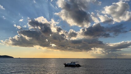 Rays breaking through clouds over the Marmara Sea, Istanbul, Turkey. Blue sky and large cloud cluster forming with diffuse clouds around. Scenic view of beautiful dramatic sunset over the ocean
