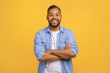 Cheerful African American Guy Smiling To Camera, Posing With Crossed Hands