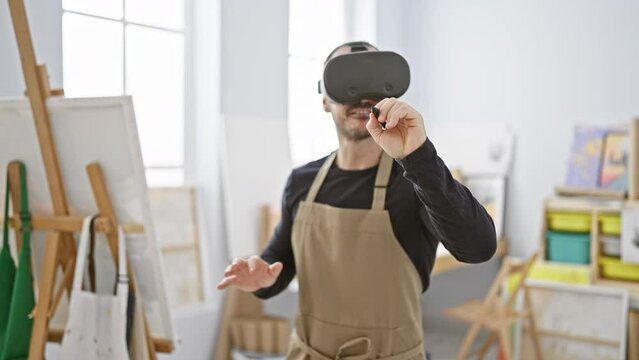 A bearded man wearing a vr headset and apron stands in an art studio expressing creativity through technology.