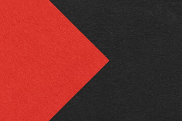 Texture of black paper background, half two colors with red arrow, macro. Structure of dense craft...