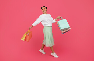 Seasonal Sales Concept. Smiling Asian Woman Walking With Shopping Bags