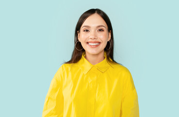 Fototapeta premium Studio portrait of cheerful young woman smiling at camera