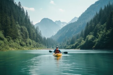 Man kayaking on a lake with a mountain and a forest in the background