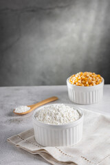 Maize starch. Cornstarch in the bowl and corn kernels.