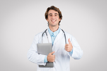 Doctor man with laptop giving thumbs up and smiling