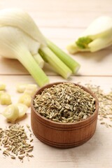 Bowl with fennel seeds on wooden table, closeup