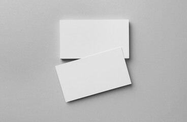 Blank business cards on light grey background, flat lay. Mockup for design