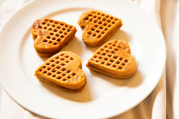 several waffles that looked delicious in the shape of a heart were served on a white plate
