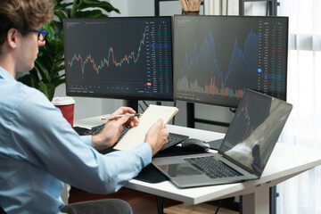 Working young professional business trader concentrating on market stock graph investing in real...