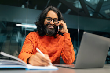 Positive indian man entrepreneur working at modern office
