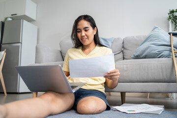 Asian woman amputee using laptop computer, work in living room at home.