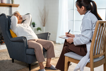 Asian caregiver nurse examine and listen to senior stress woman patient.