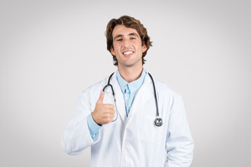 Confident male doctor giving thumbs up, positive healthcare