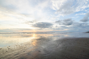 Uvita beach reflection ocean sky with clouds and sunset