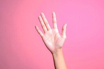 Woman hand lifted up and waving say hi or asking permission over pink background