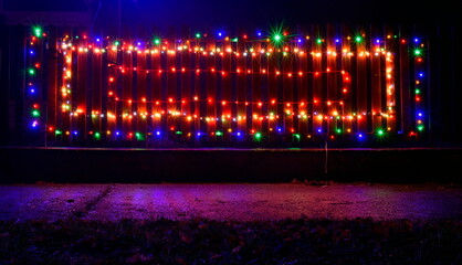 Glowing lights on the fence down the street.