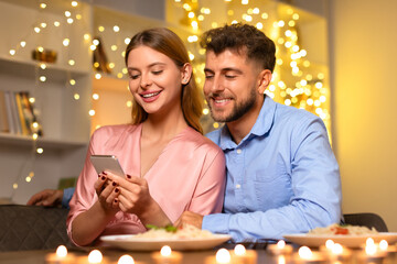 Smiling woman using phone, man looking over shoulder