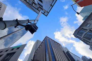 Looking up in the city: Urban view with buildings, traffic lights and banners.