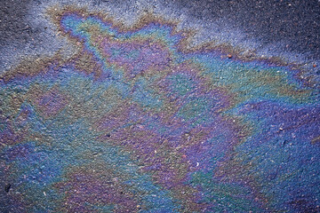 Obraz premium Textured stain of fuel or oil on wet asphalt on a rainy day