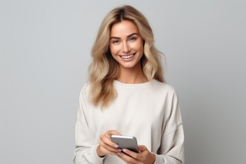 Naklejka premium Smiling Woman Holding Cell Phone, Communicating With Joy and Enthusiasm