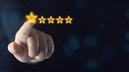 Businessman touches glowing yellow five-pointed star for excellent evaluation after customer uses ISO product service and global quality standards certification.