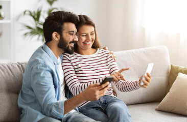Positive millennial man and woman using cell phones at home