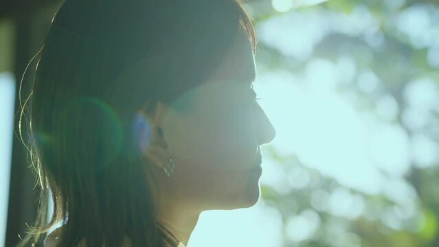 テラスから屋外を見つめる女性