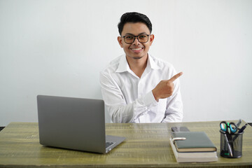 young asian businessman in a workplace pointing to the side to present a product wear white shirt isolated white background