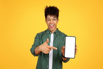 Positive african american guy pointing at phone with white screen