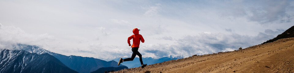 Woman trail runner cross country running at high altitude mountains