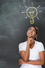 Indian woman standing in front of chalkboard with light bulb draw