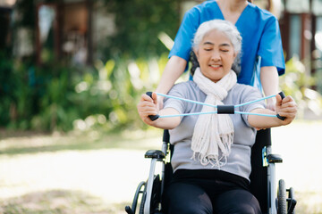 Fototapeta na wymiar Asian physiotherapist helping elderly woman patient stretching arm during exercise correct with dumbbell in hand during training hand with patient Back problems in the garden.