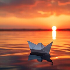Single paper boat floating on a calm body of water at sunset