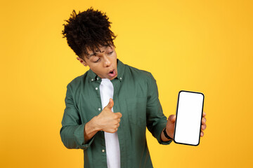 Shocked young black guy looking at smartphone