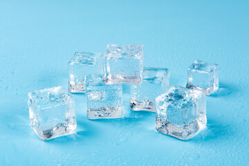 Ice cubes with water drops on a blue background.