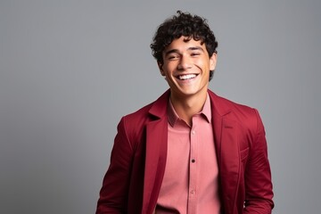 Fototapeta na wymiar Portrait of a smiling young man with curly hair against grey background