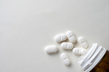 White pills scattered on a white background