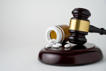 Gavel and pills on a white background with copy space