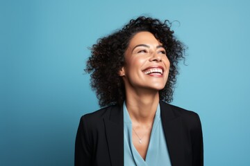 Portrait of a happy african american businesswoman laughing against blue background