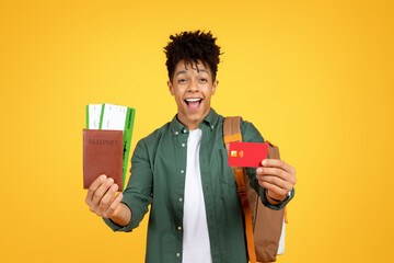 Happy black guy tourist showing credit card and passport