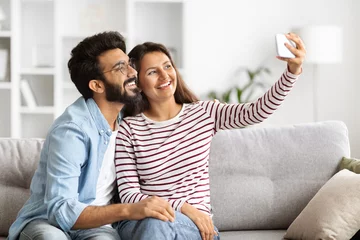 Foto op Plexiglas Indian man and woman taking selfie on smartphone at home © Prostock-studio