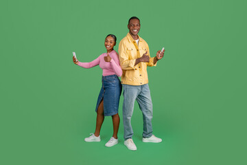 Happy black man and woman with phones in their hands